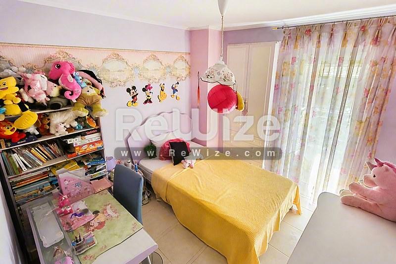 Φωτεινό παιδικό δωμάτιο σε μονοκατοικία στη Χαλκιδική με κίτρινο κρεβάτι και ροζ τοίχους.