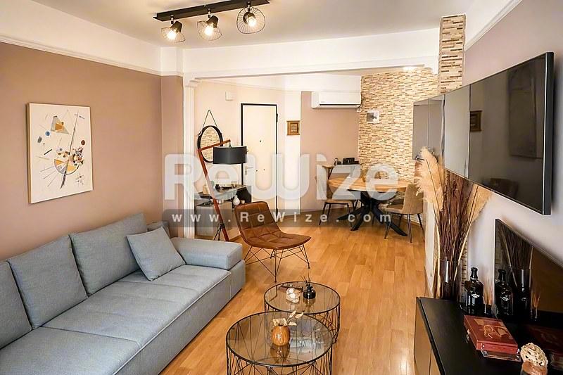 Σύγχρονο σαλόνι σε διαμέρισμα στη Χαλκιδική με γκρίζο καναπέ, ξύλινο δάπεδο και σύγχρονα έπιπλα.