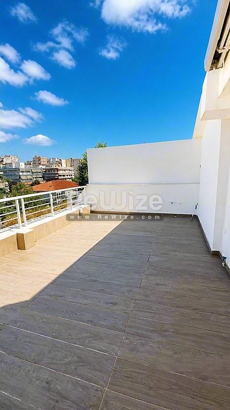 Ευρύχωρη βεράντα σύγχρονης μεζονέτας στη Χαλκιδική με θέα θάλασσας και ξύλινο δάπεδο.