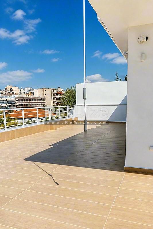 Ευρύχωρη βεράντα μεζονέτας στη Χαλκιδική με πανοραμική θέα και σύγχρονη ξύλινη επίστρωση.