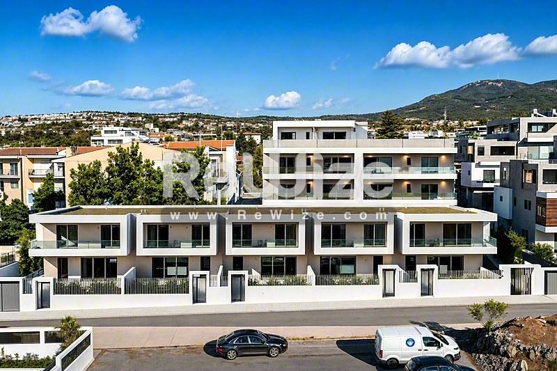 Σύγχρονη πρόσοψη διαμερίσματος στη Χαλκιδική με σύνταξη ανάλογη του 21ου αιώνα και λευκή εξωτερική επιφάνεια.