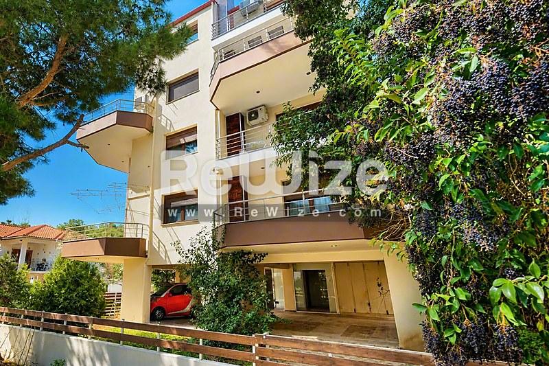 Σύγχρονη μεζονέτα στη Χαλκιδική με κισσοκαλυμμένους τοίχους και ευρύχωρα μπαλκόνια.