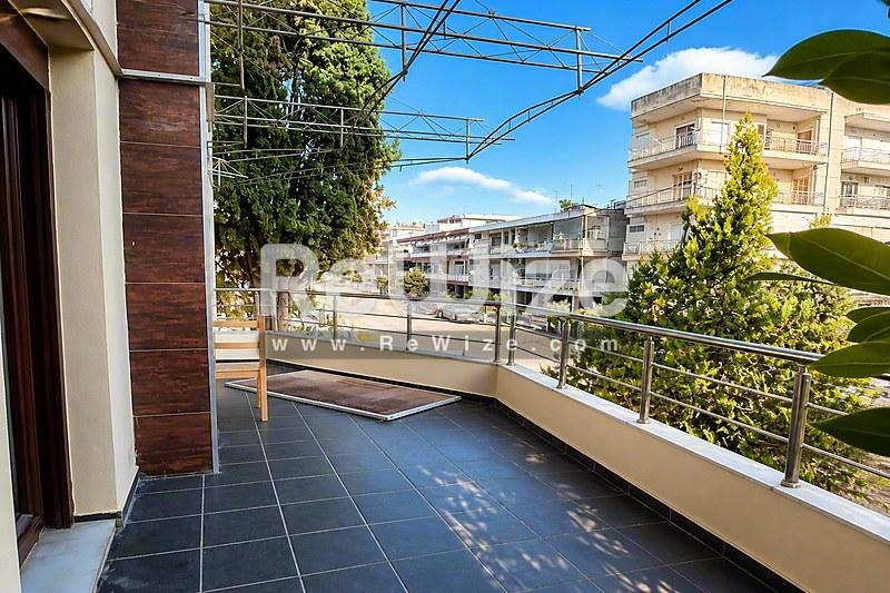 Ευρύχωρη βεράντα μεζονέτας στη Χαλκιδική με σύγχρονα πλακάκια και πανοραμική θέα στη γειτονιά.