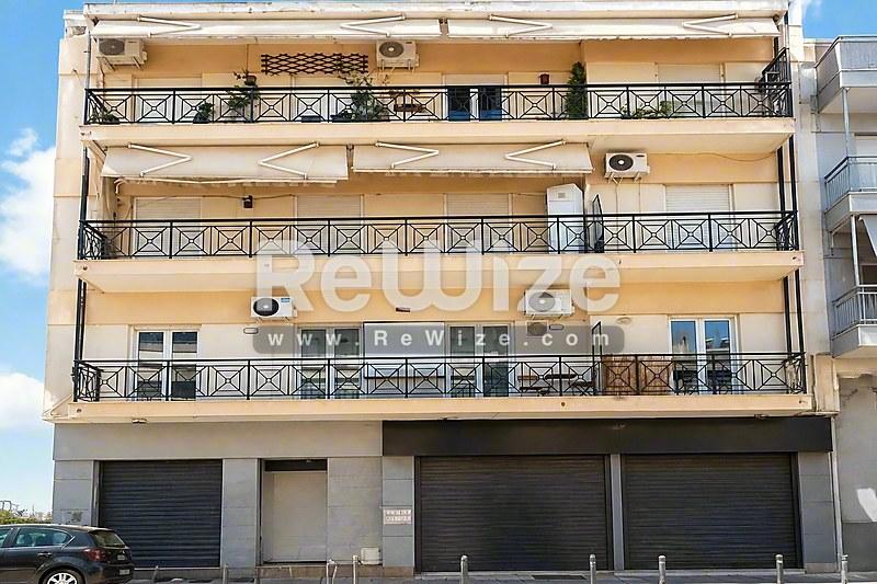 Σύγχρονη πολυκατοικία στην Χαλκιδική με μπαλκόνια, γκαράζ ισογείου και σύνθετο αρχιτεκτονικό σχέδιο.