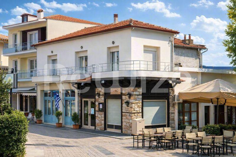 Πρόσοψη ανεξάρτητης κατοικίας στη Χαλκιδική με μπλε παντζούρια στο ισόγειο και κατοικήσιμους ορόφους.
