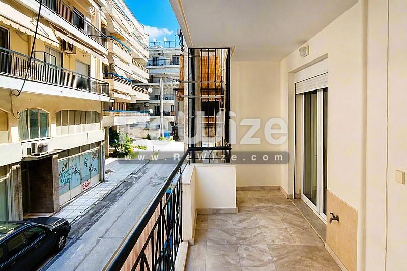 Ευρύχωρο μπαλκόνι διαμερίσματος στη Χαλκιδική με θέα σε κατοικίες και δρόμο.