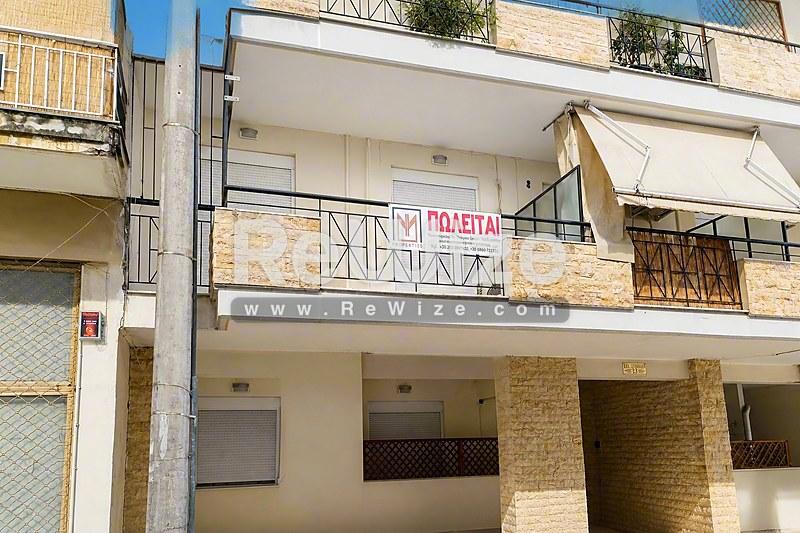 Σύγχρονη πρόσοψη διαμερίσματος στη Χαλκιδική με μπαλκόνια και χώρο στάθμευσης ισογείου.