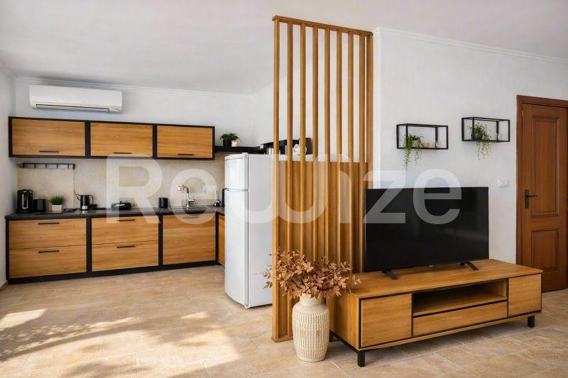 Σύγχρονη κουζίνα και σαλόνι διαμερίσματος στην Χαλκιδική με ξύλινα έπιπλα και στοιχεία διακόσμησης.