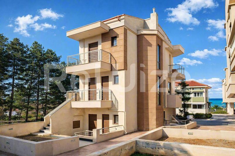 Σύγχρονη τριώροφη μεζονέτα με πρόσοψη από τούβλο και κρεμώδες επίχρισμα στη Χαλκιδική.