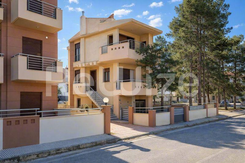 Σύγχρονη μεζονέτα στη Χαλκιδική με καμπύλα μπαλκόνια, ζεστή πέτρινη όψη και σχέδιο αρχιτεκτονικής.