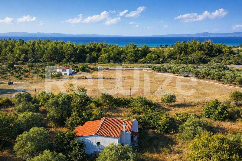 Εναέρια άποψη μονοκατοικίας με κεραμοσκεπή στη Χαλκιδική, περιτριγυρισμένη από πράσινη βλάστηση.