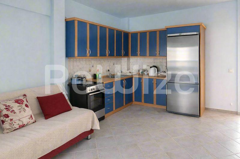 Σύγχρονη κουζίνα με μπλε ντουλάπες σε μεζονέτα της Χαλκιδικής, με inox συσκευές και ανοιχτό χώρο διαβίωσης.