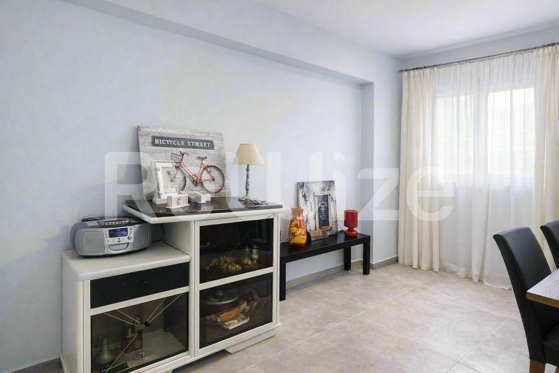 Φωτεινό σαλόνι μεζονέτας στη Χαλκιδική με σύγχρονη διακόσμηση, ντουλάπες και μεγάλα παράθυρα με φυσικό φως.