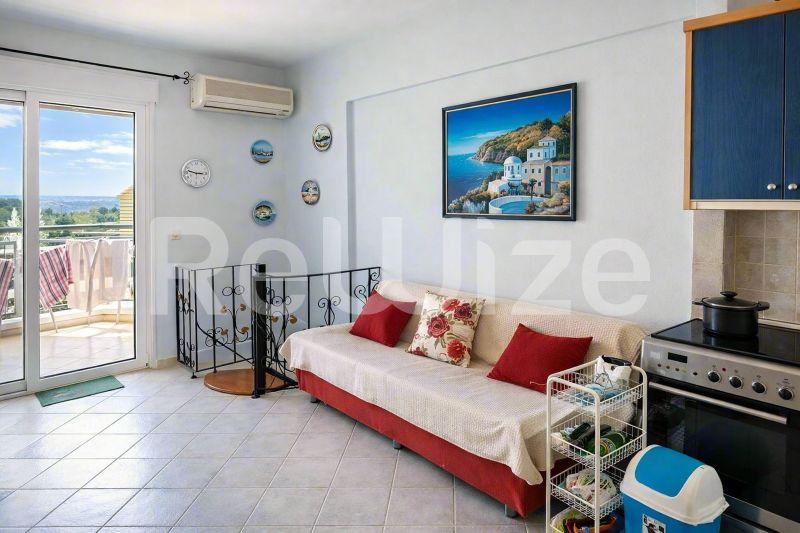 Φωτεινό σαλόνι μεζονέτας στη Χαλκιδική με άνετη κάθιση και θέα από το μπαλκόνι.