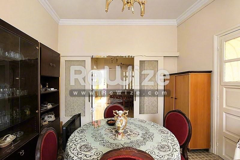 Κομψό τραπεζαρία διαμερίσματος στη Χαλκιδική με στρογγυλό τραπέζι, δαντελένιο τραπεζόμαντιλο και μπορντό καρέκλες.