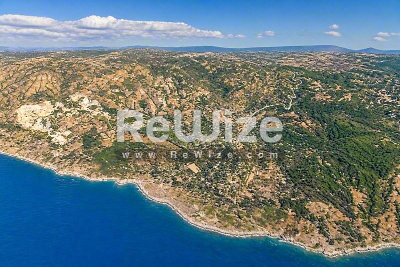 Εναέρια άποψη οικοπέδου στην Χαλκιδική με πράσινη βλάστηση και γαλάζια θάλασσα.