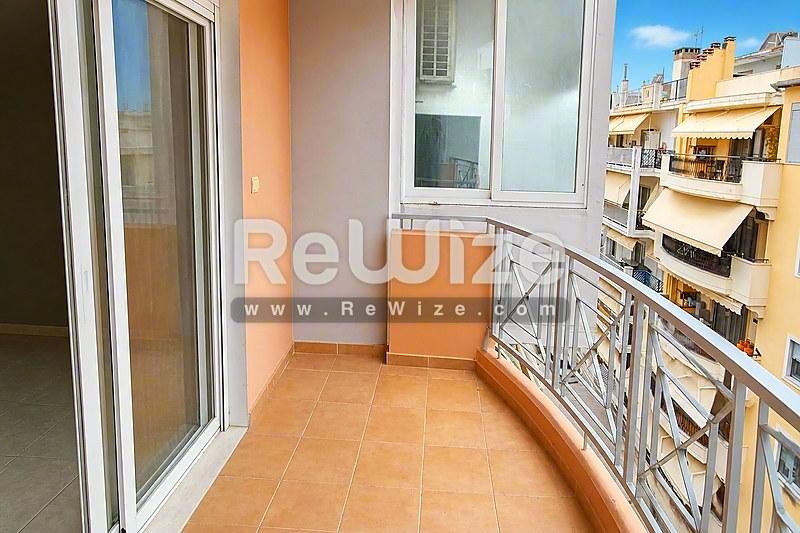 Ηλιόλουστο μπαλκόνι διαμερίσματος στη Χαλκιδική με πήλινα πλακάκια και θέα στη θάλασσα.