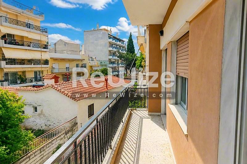 Ευρύχωρο μπαλκόνι διαμερίσματος στη Χαλκιδική με θέα σε αυλή με μεσογειακή αρχιτεκτονική.