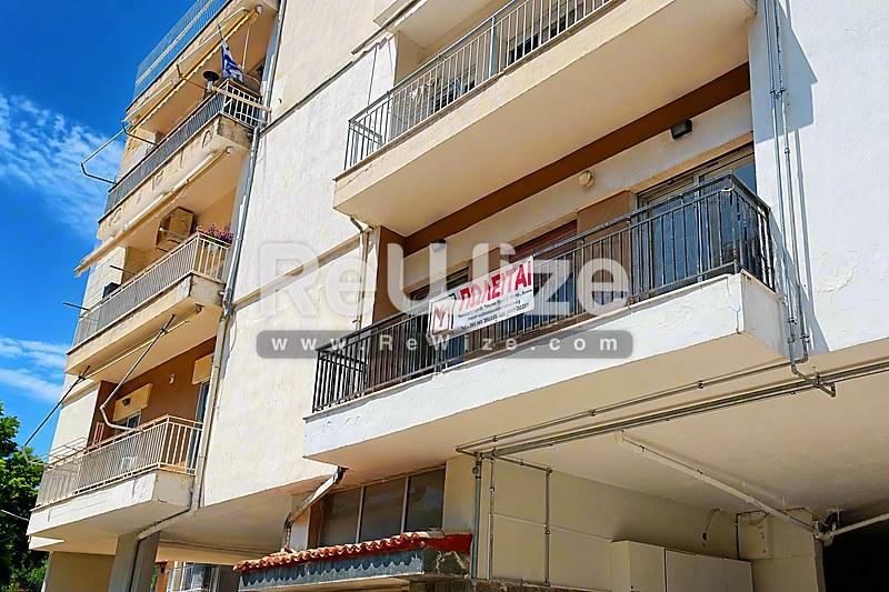 Σύγχρονη πολυκατοικία στη Χαλκιδική με πολλά μπαλκόνια και χώρο στάθμευσης ισογείου.