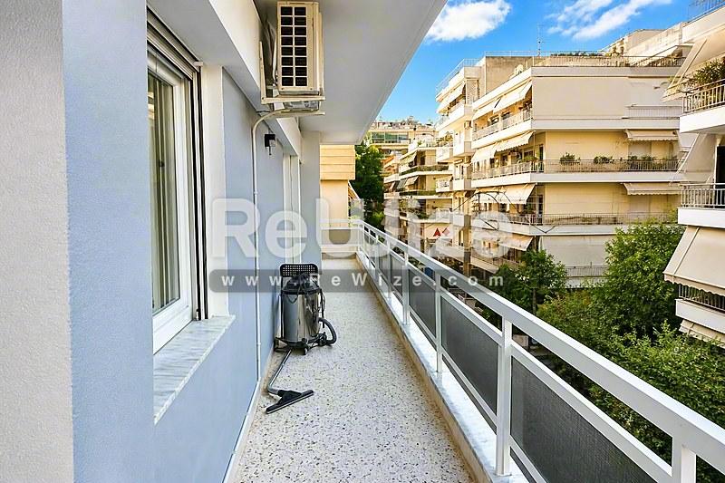 Просторο μπαλκόνι διαμερίσματος στη Χαλκιδική με σύγχρονη κάγκελα και θέα σε κτίρια και πράσινο.