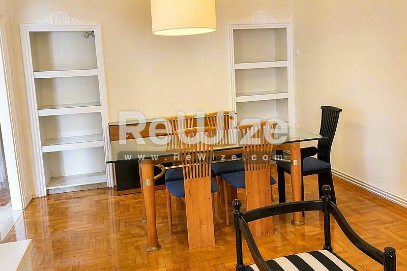 Τραπεζαρία διαμερίσματος στη Χαλκιδική με ξύλινο δάπεδο, τραπέζι και ενσωματωμένα ράφια.