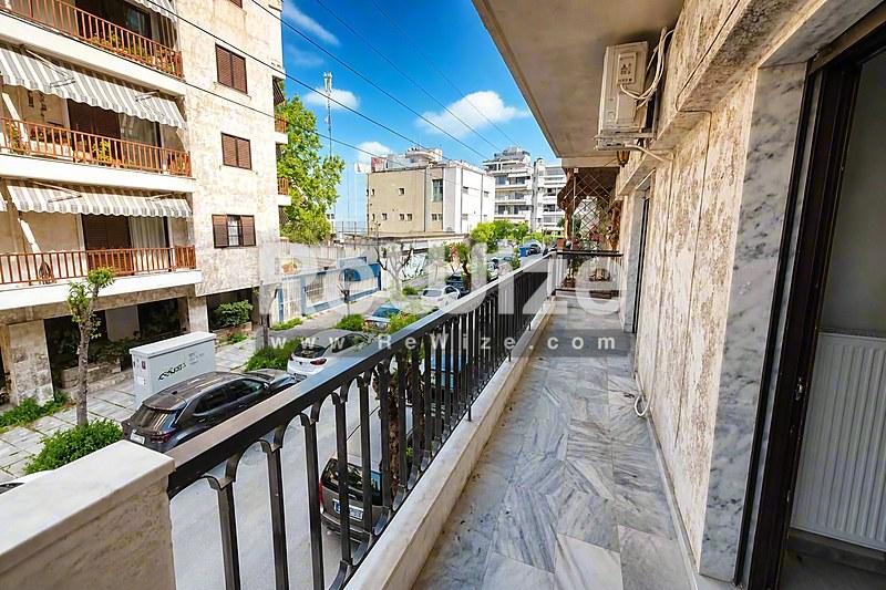 Ευρύχωρο μπαλκόνι διαμερίσματος στη Χαλκιδική με θέα σε ηλιόλουστο μεσογειακό δρόμο.