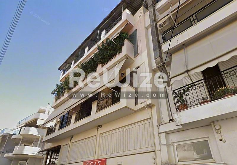 Σύγχρονη πολυκατοικία στη Χαλκιδική με διαμερίσματα, πολλά μπαλκόνια με φυτά και σύγχρονη αρχιτεκτονική.