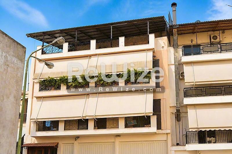 Σύγχρονη πολυκατοικία στη Χαλκιδική με μπαλκόνια και πράσινα φυτά σε ενδιαφέρον αρχιτεκτονικό σχέδιο.