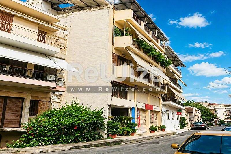 Πρόσοψη διαμερίσματος στη Χαλκιδική με πολλαπλά μπαλκόνια και πράσινη βλάστηση.