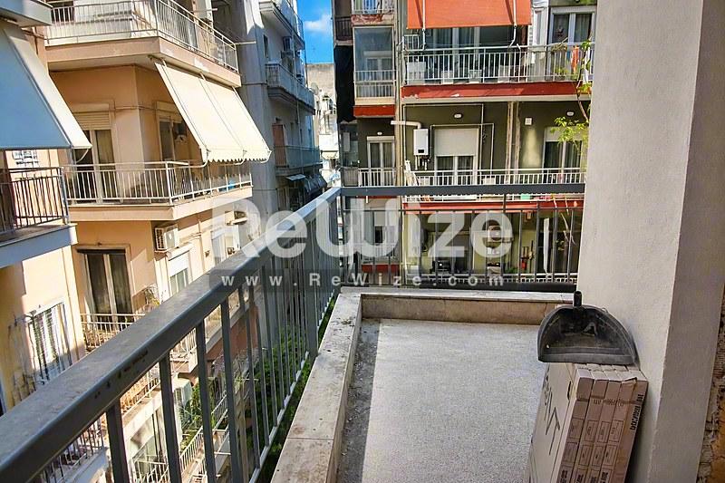Просторbalkόνι διαμερίσματος στη Χαλκιδική με θέα σε γειτονικά κατοικίδια με σύγχρονη αρχιτεκτονική.