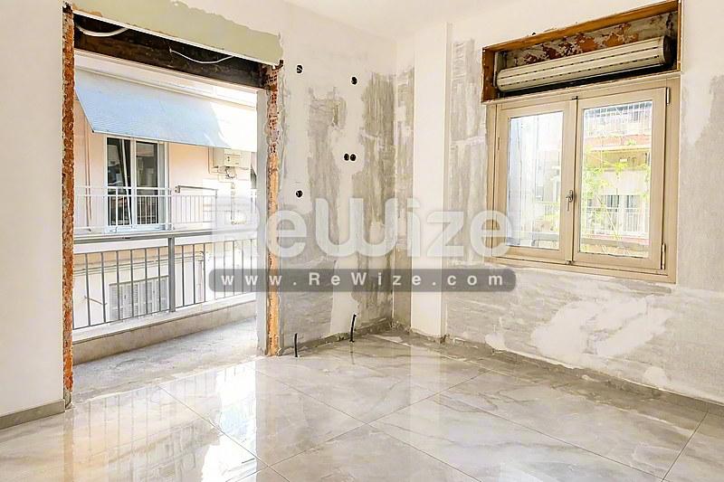 Φωτεινό υπνοδωμάτιο διαμερίσματος στη Χαλκιδική με μάρμαρο και μεγάλα παράθυρα.