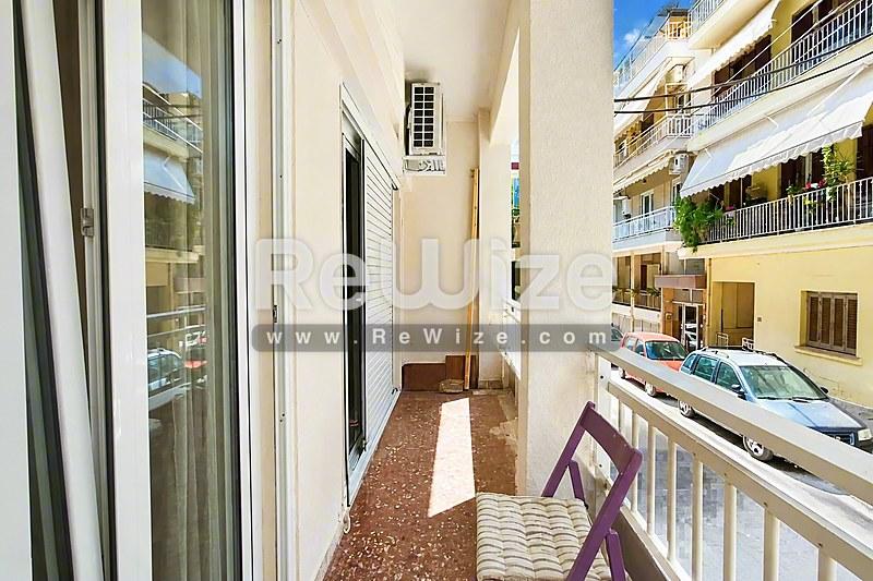 Φωτεινός διάδρομος και πρόσβαση μπαλκονιού σε διαμέρισμα της Χαλκιδικής με σύγχρονες γυάλινες πόρτες.