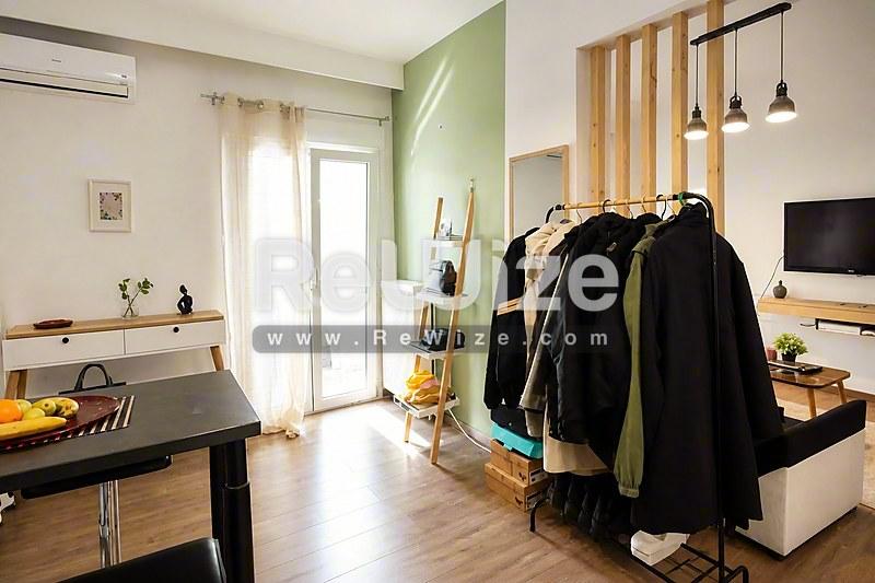 Σύγχρονο μπάνιο διαμερίσματος στη Χαλκιδική με μαύρη νιπτήρα, πράσινο τοίχο και σύγχρονες εγκαταστάσεις.