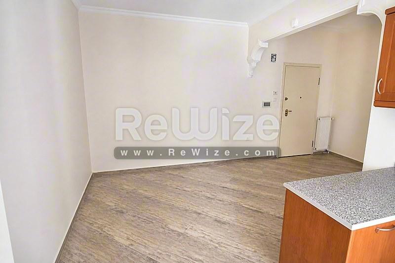Φωτεινό σαλόνι μονοκατοικίας στη Χαλκιδική με μαρμάρινο δάπεδο και γυάλινες πόρτες προς τον κήπο.
