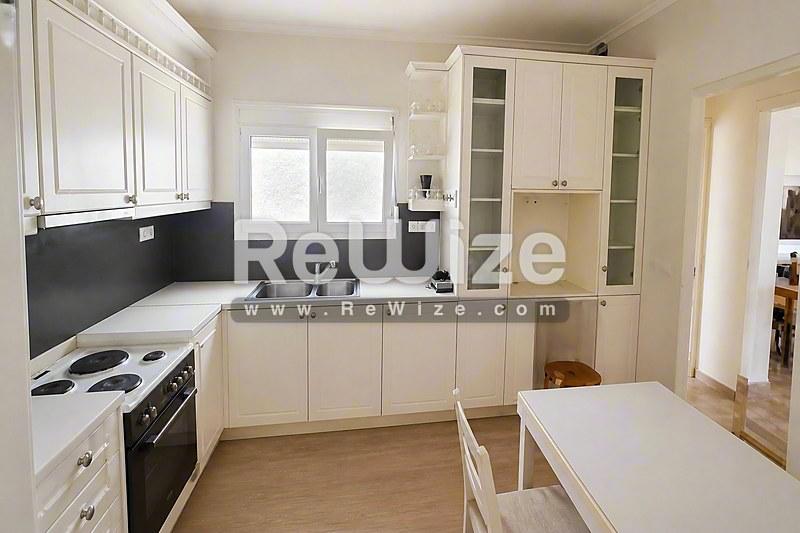 Φωτεινό σαλόνι μονοκατοικίας στη Χαλκιδική με μάρμαρο, γυάλινες πόρτες και σύγχρονη οροφή.