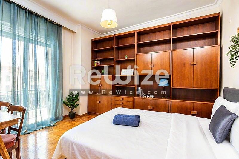 Φωτεινό σαλόνι α独立ής κατοικίας στη Χαλκιδική με μαρμάρινο δάπεδο και γαλλικές πόρτες που ανοίγουν σε βεράντα.