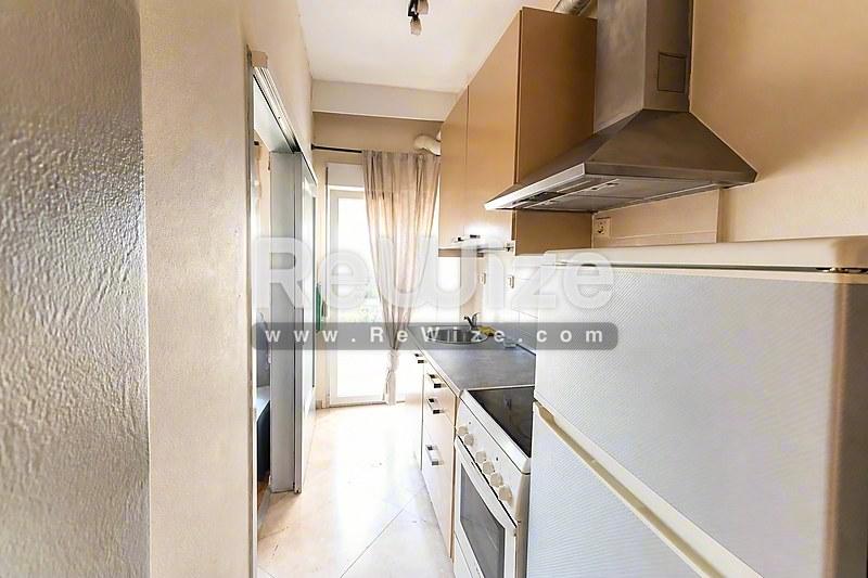 Φωτεινό σαλόνι μονοκατοικίας στη Χαλκιδική με μάρμαρο, γυάλινες πόρτες και σύγχρονη οροφή.