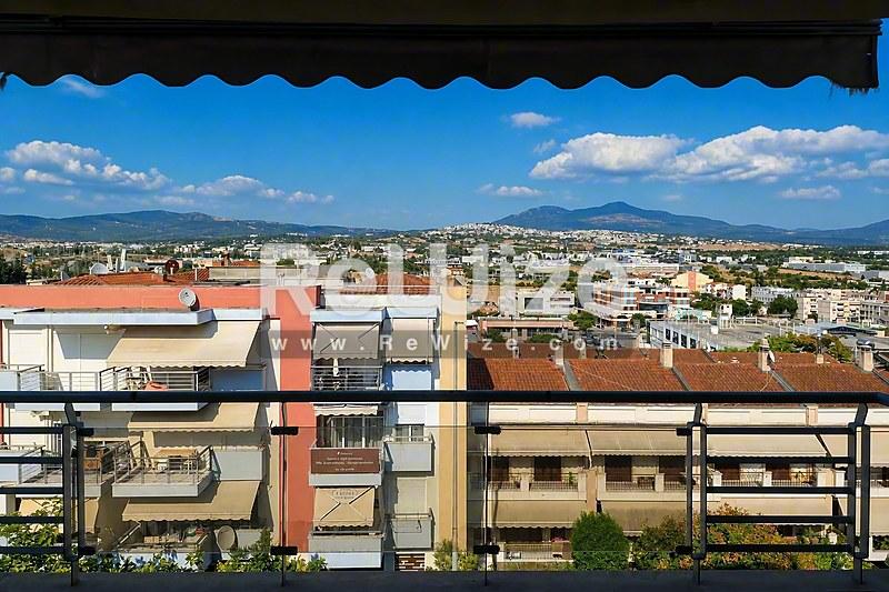 Φωτεινό σαλόνι μονοκατοικίας στη Χαλκιδική με μάρμαρο, γυάλινες πόρτες και σύγχρονη οροφή.
