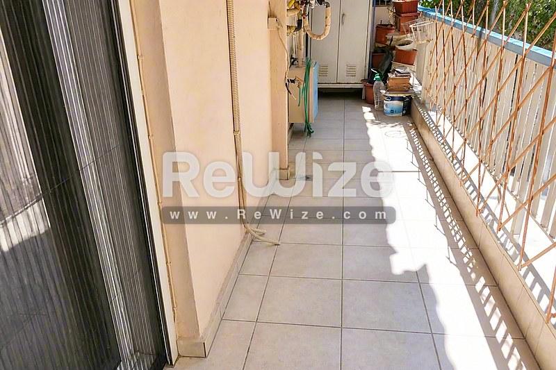 Φωτεινό σαλόνι α独立ής κατοικίας στη Χαλκιδική με μαρμάρινο δάπεδο και γαλλικές πόρτες που ανοίγουν σε βεράντα.
