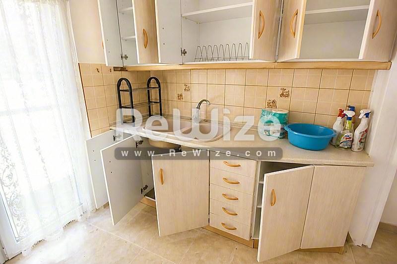 Σύγχρονη πρόσοψη μονοκατοικίας στη Χαλκιδική με λιθόκτιστη τοιχοποιία, γυάλινη περγόλα και θέα θάλασσας.