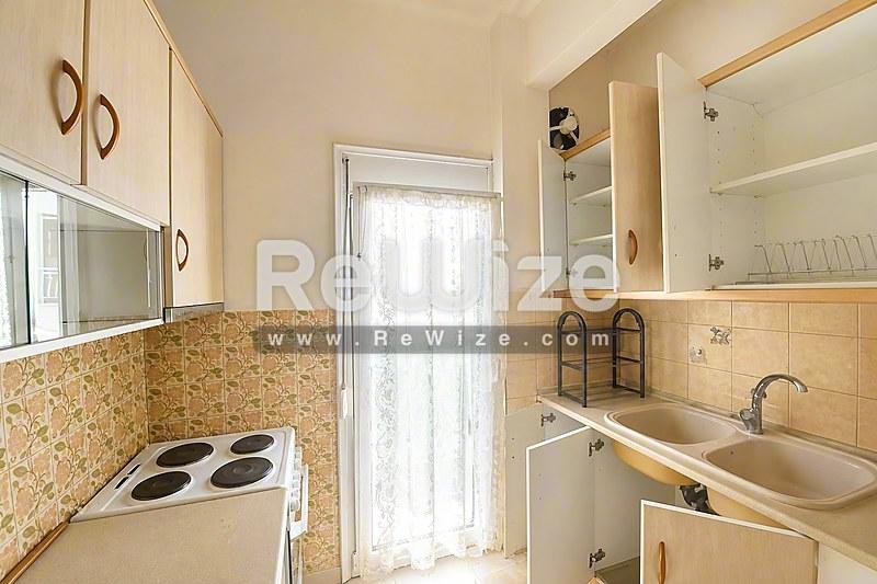 Φωτεινό σαλόνι μονοκατοικίας στη Χαλκιδική με μάρμαρο, γυάλινες πόρτες και σύγχρονη οροφή.