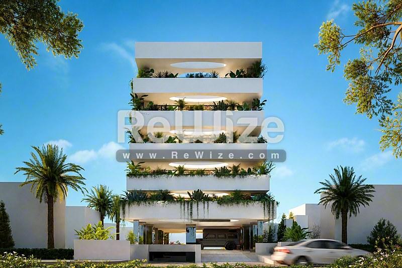 Σύγχρονη πολυκατοικία στη Χαλκιδική με κλιμακωτά μπαλκόνια και πολλή πράσινη βλάστηση.