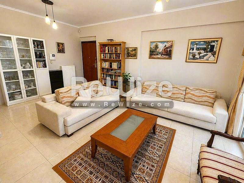 Φωτεινό σαλόνι του ακινήτου rw-7479 στη Χαλκιδική με άνετη καθιστική και βιβλιοθήκες.