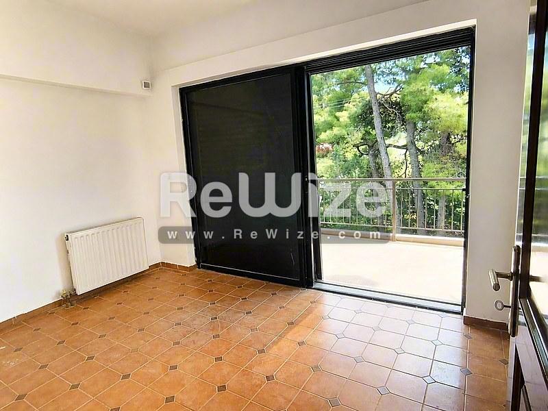 Φωτεινό σαλόνι στο διαμέρισμα Halkidiki rw-7551 με πήλινα πλακάκια και θέα στο δάσος.