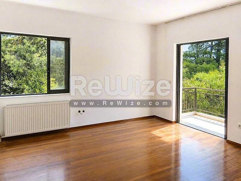 Φωτεινό σαλόνι στο ακίνητο Halkidiki rw-7551 με ξύλινα δάπεδα και θέα στον κήπο.