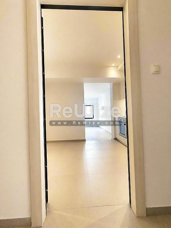 Φωτεινός διάδρομος στο ακίνητο Halkidiki rw-7556 με σύγχρονο δάπεδο και ανοιχτή πόρτα.