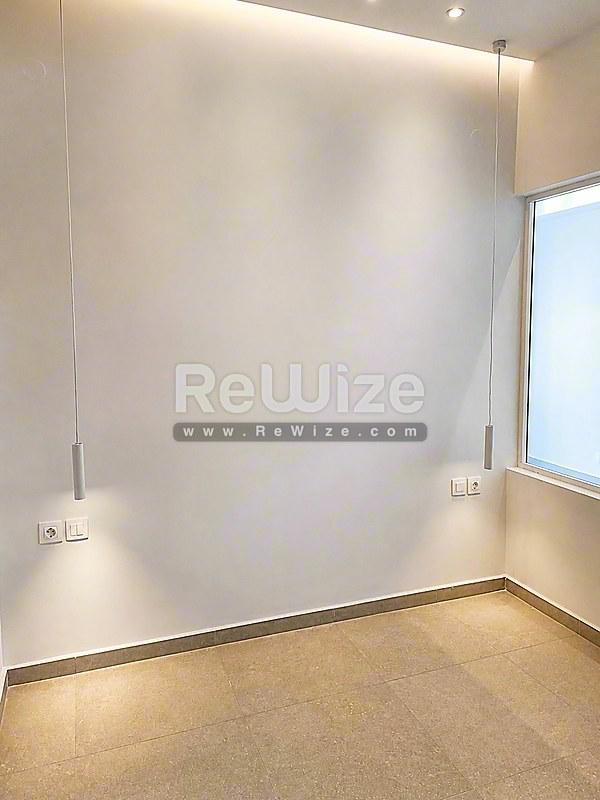 Σύγχρονο σαλόνι στο διαμέρισμα Halkidiki rw-7556 με λευκούς τοίχους, φυσικό φως και πάτωμα φελλού.