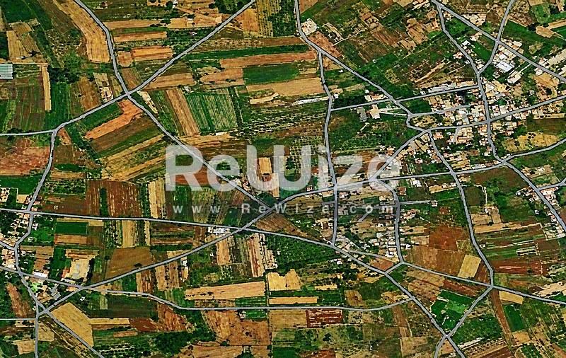 Εναέρια άποψη γεωργικών εκτάσεων στη Χαλκιδική με χωράφια σε σχέδιο και διάσπαρτα οικισμό.