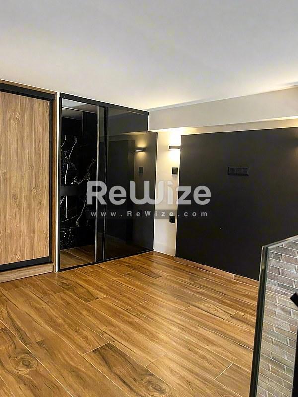 Σύγχρονο μπάνιο του ακινήτου rw-7617 στη Χαλκιδική με μαύρα φωτιστικά και ζεστό ξύλινο δάπεδο.