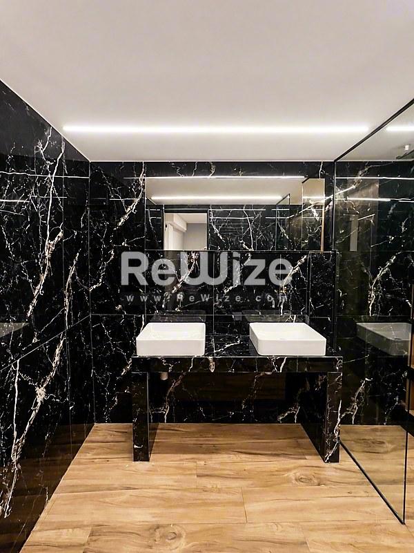 Κύριο μπάνιο της βίλας rw-7617 στη Χαλκιδική με μαύρο μάρμαρο, διπλό νιπτήρα και ξύλινο δάπεδο.